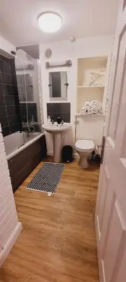 a bathroom with a tub and a toilet and a sink at C8 Bay Apartments - Fistral Beach View - Newquay in Newquay
