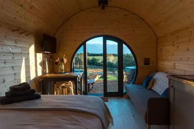 a room with a bed and a room with an open door at Stargaze at OLJU Lodges in Stithians