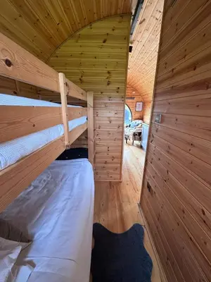a bedroom with two bunk beds in a wooden cabin at Stargaze at OLJU Lodges in Stithians