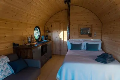 a bedroom with a bed in a log cabin at Stargaze at OLJU Lodges in Stithians