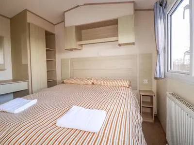 a bedroom with a bed with two towels on it at Little Trevorrick Caravan in Wadebridge
