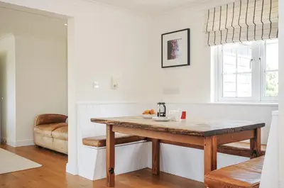 a kitchen with a wooden table in a room at Bodare 8 in Wadebridge