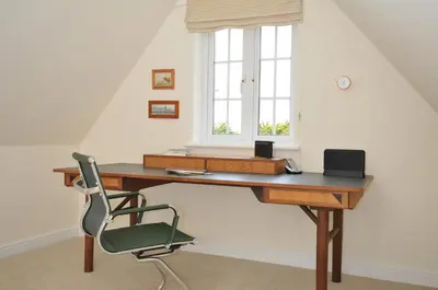 a desk with a chair and a window at Bodare 8 in Wadebridge