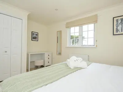 a white bedroom with a bed with towels on it at Bodare 8 in Wadebridge
