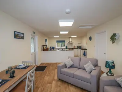 a living room with a couch and a table at Kingfisher Lodge in St Austell