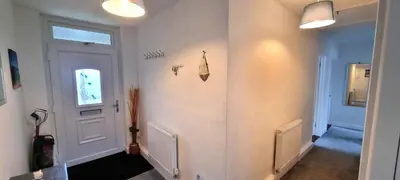 a hallway with a white door and a window at Cornerways, Nr Perranporth in Perranzabuloe