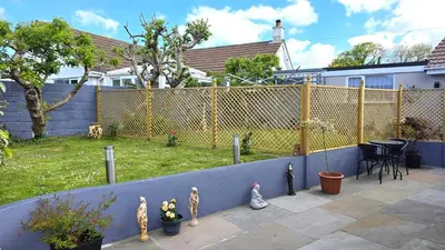 a backyard with a fence and a yard at Cornerways, Nr Perranporth in Perranzabuloe