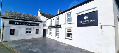 a white building with a sign for the new inn at Cornerways, Nr Perranporth in Perranzabuloe