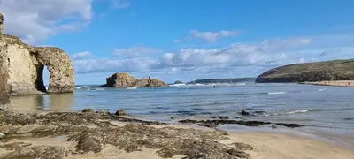 a beach with large rocks in the water at Cornerways, Nr Perranporth in Perranzabuloe
