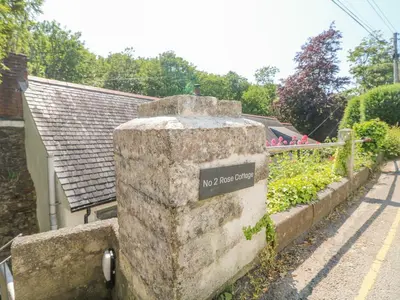 a stone wall with a sign that says my house garden at 2 Rose Cottage in St. Agnes