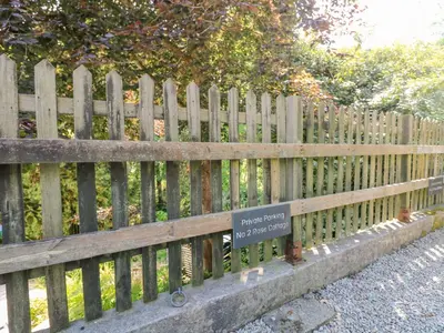a wooden fence with a sign on it at 2 Rose Cottage in St. Agnes