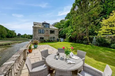 a patio with a table and chairs in front of a house at 2 Bed in Little Petherick oc-o30788 in Little Petherick