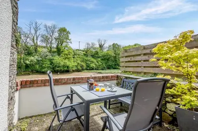 a patio with a table and chairs on a balcony at 2 Bed in Little Petherick oc-o30788 in Little Petherick