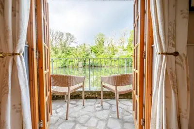 a room with a balcony with two chairs and a window at 1 Bed in Little Petherick oc-a30789 in Little Petherick
