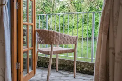 a wicker chair sitting on a porch next to a window at 1 Bed in Little Petherick oc-a30789 in Little Petherick