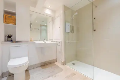 a white bathroom with a toilet and a shower at 1 Bed in Little Petherick oc-a30789 in Little Petherick