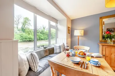 a dining room with a table and a couch at 1 Bed in Little Petherick oc-a30789 in Little Petherick