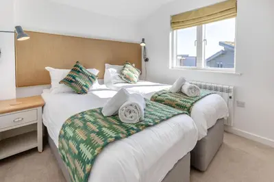 a bedroom with two beds and a desk and a window at 4 Bed in Lelant oc-a30881 in Carbis Bay