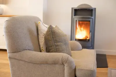 a chair with a pillow in front of a fireplace at 4 Bed in Lelant oc-a30881 in Carbis Bay