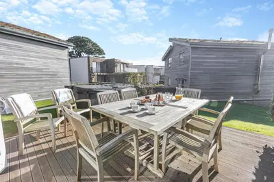 a wooden table and chairs on a wooden deck at 4 Bed in Lelant oc-a30881 in Carbis Bay