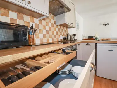 a kitchen with a counter top with a microwave at Swallow Cottage in St Austell