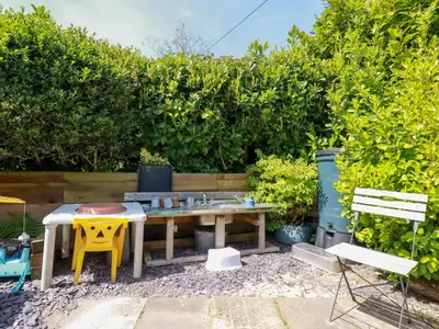 a picnic table and two chairs in a garden at Swallow Cottage in St Austell