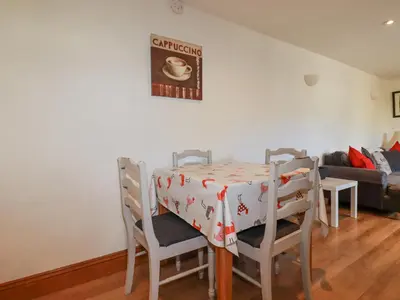 a dining room with a table and chairs and a couch at The Hayloft in St Austell