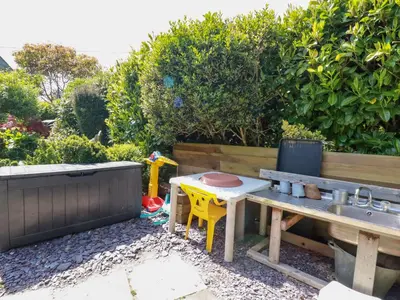 a garden with a bench and a table and a sink at The Hayloft in St Austell