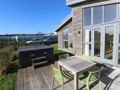 a patio with a table and chairs and a grill at Una, Lodge 77 in St Ives