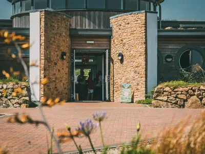 a door to a building with people walking into it at Una, Lodge 77 in St Ives