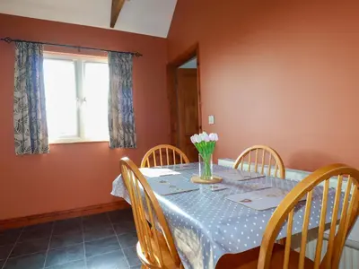 a dining room with a table and chairs at The Old Milking Parlour in Par