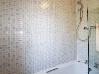 a bathroom with a shower and a bath tub at The Old Milking Parlour in Par