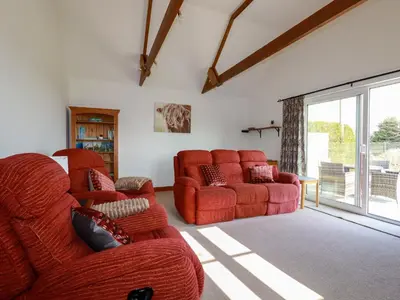a living room with two chairs and a couch at The Old Milking Parlour in Par