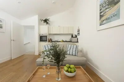 a living room with a couch and a bowl of fruit on a table at 55 Una in Carbis Bay