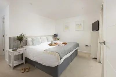 a bedroom with a large bed and a tv at 55 Una in Carbis Bay