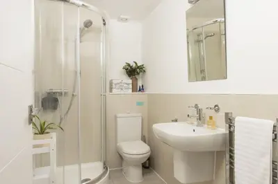 a bathroom with a toilet and a sink and a shower at 55 Una in Carbis Bay