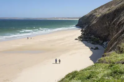 a group of people walking on a beach at 55 Una in Carbis Bay