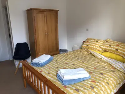 a bedroom with a bed with towels on it at Captains Rest - Contemporary 4 bed apartment in Falmouth