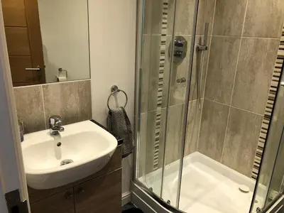 a bathroom with a sink and a shower at Captains Rest - Contemporary 4 bed apartment in Falmouth