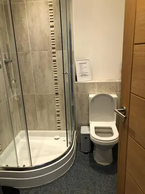 a bathroom with a shower and a toilet and a sink at Captains Rest - Contemporary 4 bed apartment in Falmouth