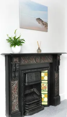 an old black fireplace with a painting above it at Gordon House B & B in Tintagel