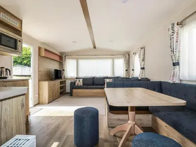 a living room with a blue couch and a table at 82 Hillside in Newquay
