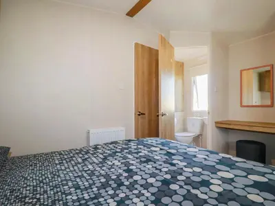 a bedroom with a bed and a bathroom with a toilet at 82 Hillside in Newquay