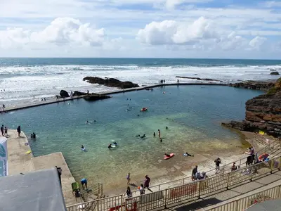 people swimming in a swimming pool at the beach at Rosebud Beach Hut in Otterham