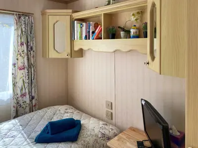 a small bedroom with a bed and a medicine cabinet at Demelzas Retreat in Redruth
