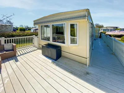 a house on a wooden deck with a window at Demelzas Retreat in Redruth