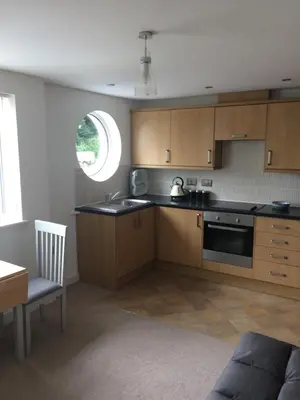 a kitchen with wooden cabinets and a sink and a window at 11 longstone house St ives carbis bay in Carbis Bay