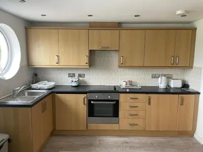 a kitchen with wooden cabinets and a sink at 11 longstone house St ives carbis bay in Carbis Bay