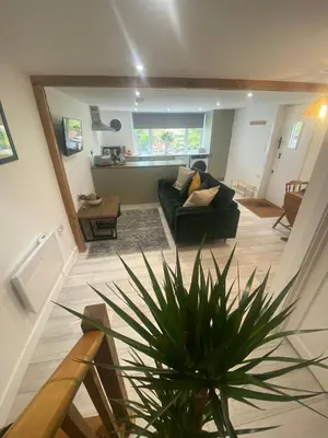 a living room with a couch and a potted plant at The Porthole in Port Isaac