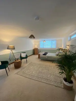 a living room with a bed and a potted plant at The Porthole in Port Isaac